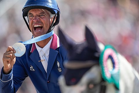 Karim Florent Laghouag celebrates his team's silver medal in equestrian Jumping